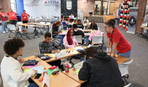 Lori Tiller, UGA Fanning Institute public service faculty, helps Clarke County high school students participating in the Georgia Possible program work through a design thinking project that combines teamwork and entrepreneurial concepts on November 10, 2023, at the UGA Innovation District.